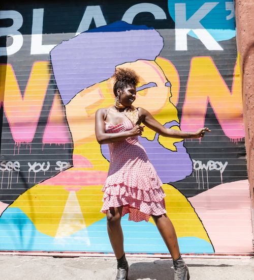 Woman performing a dynamic cardio movement with a joyful expression.